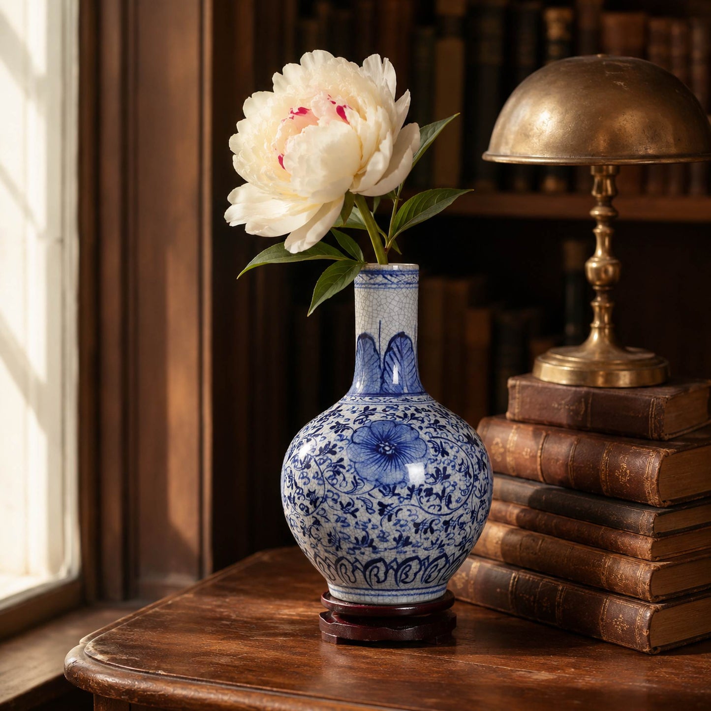 Blue and white porcelain celestial globe vase styled on wooden side table with peony