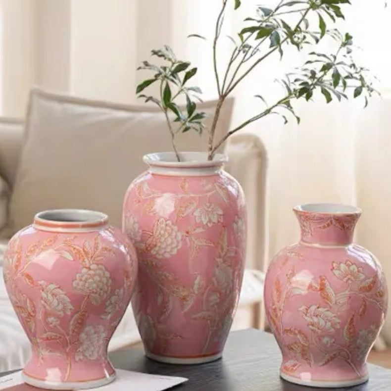 Three pink ceramic vase shapes on a dark surface beside a cosy sofa — Holm & Hearth