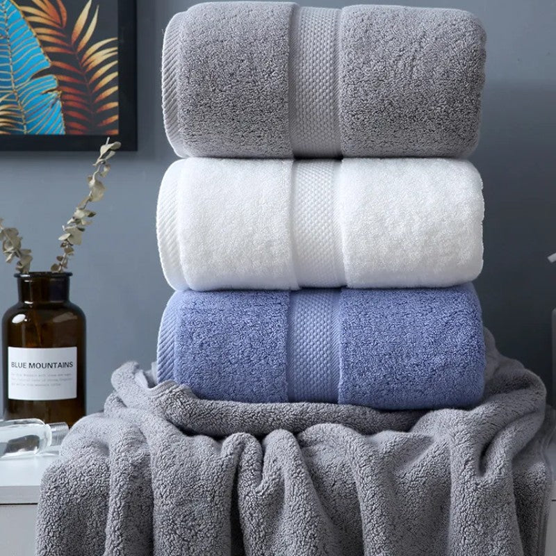 Three rolled cotton bath towels styled with eucalyptus stems — Holm & Hearth