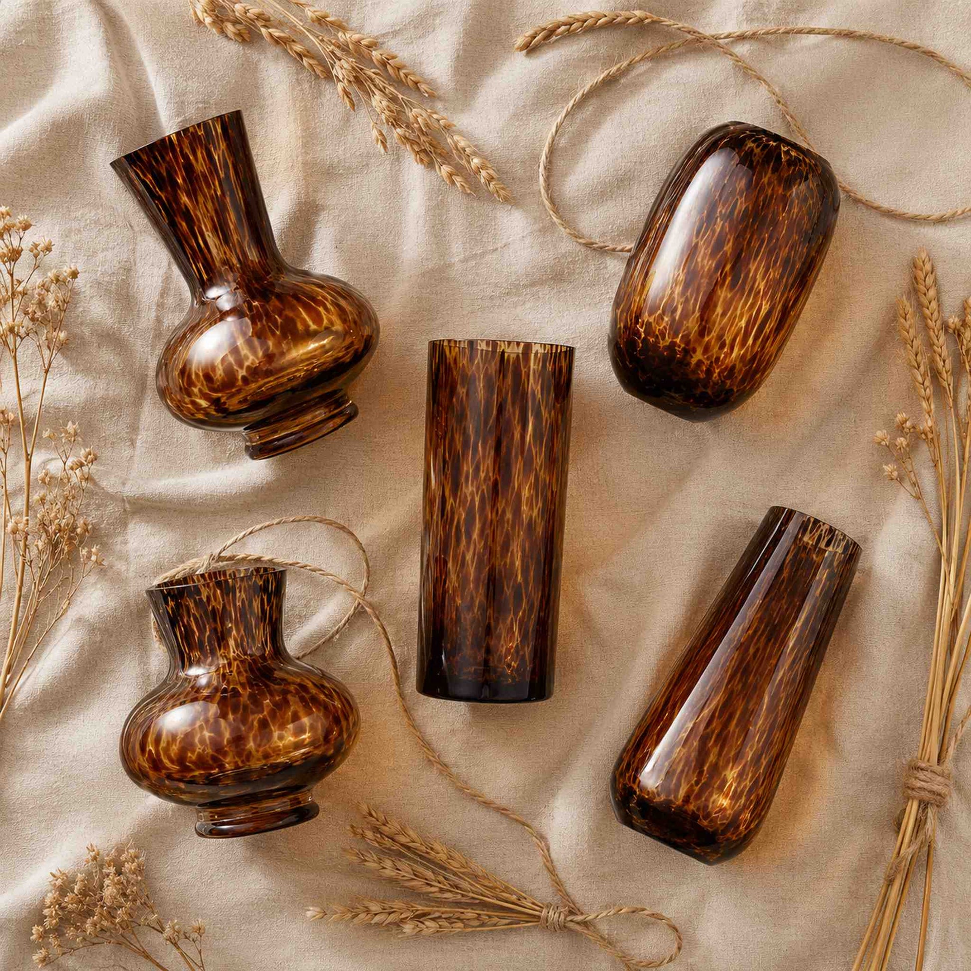 Leopard print glass vase flat lay of all five sculptural amber shapes on honey linen