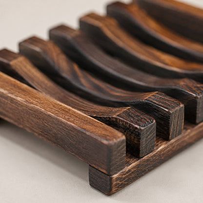 Wooden soap rack detail close-up showing slatted construction and charred finish texture, macro shot